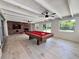 Game room features a billiard table, brick fireplace and a sliding glass door to the backyard at 2720 12Th Ave W, Bradenton, FL 34205