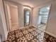 Hallway with decorative tile flooring, mirror, and doorways leading to various rooms at 2720 12Th Ave W, Bradenton, FL 34205