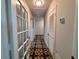 Hallway featuring decorative tile flooring, glass doors and a built-in cupboard for ample storage at 2720 12Th Ave W, Bradenton, FL 34205
