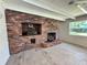 Living room boasts a brick fireplace, bright window and neutral plank flooring at 2720 12Th Ave W, Bradenton, FL 34205