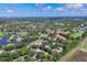 Expansive aerial view of neighborhood featuring trees, a golf course, and a pond at 2816 Breton Woods, Sarasota, FL 34235