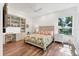 Bright bedroom features a built-in shelving and a desk, complemented by a floral-patterned bedspread at 2816 Breton Woods, Sarasota, FL 34235
