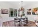 Elegant dining room boasts a modern table, chandelier lighting, and hardwood floors at 2816 Breton Woods, Sarasota, FL 34235