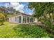 Exterior view of home's sunroom addition with large windows overlooking backyard at 2816 Breton Woods, Sarasota, FL 34235