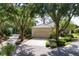 Charming home featuring a tile roof, neutral exterior paint, mature landscaping, and a spacious driveway at 2816 Breton Woods, Sarasota, FL 34235