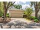 Well-maintained single-story home with a two-car garage, an extra-wide driveway, and mature shade trees at 2816 Breton Woods, Sarasota, FL 34235