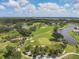 Aerial view of a lush golf course with mature trees and beautiful waterways on a sunny day at 2816 Breton Woods, Sarasota, FL 34235