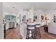 Open kitchen with breakfast bar, white cabinets, stainless appliances, and hardwood floors at 2816 Breton Woods, Sarasota, FL 34235