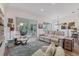 Open-concept living room featuring comfortable seating, built-in shelving, and access to sunroom at 2816 Breton Woods, Sarasota, FL 34235