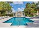 Community pool with a covered lounge area, ample seating, and lush landscaping at 2816 Breton Woods, Sarasota, FL 34235