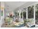 Bright sunroom with tile flooring, comfortable furniture, and walls of windows at 2816 Breton Woods, Sarasota, FL 34235