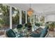 Dining table inside sunroom with sliding glass doors overlooking natural views at 2816 Breton Woods, Sarasota, FL 34235