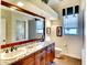 Bathroom features a double vanity with granite countertops, wood cabinets, and a large mirror at 2901 Little Country Rd, Parrish, FL 34219