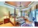 Luxurious bedroom with four-poster bed, tray ceiling, and access to a balcony at 2901 Little Country Rd, Parrish, FL 34219