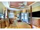 Serene bedroom with tray ceiling, four-poster bed, and view of the pool area at 2901 Little Country Rd, Parrish, FL 34219