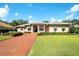 Inviting home exterior boasts a tiled roof, covered entryway, immaculate landscaping, and a brick paved drive at 2901 Little Country Rd, Parrish, FL 34219