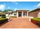 Inviting home exterior boasts a tiled roof, covered entryway, immaculate landscaping, and a brick paved drive at 2901 Little Country Rd, Parrish, FL 34219