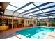 Screened-in pool with brick patio, covered seating area, and clear roof for year-round enjoyment at 2901 Little Country Rd, Parrish, FL 34219
