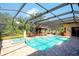 Sparkling pool and spa with brick patio and screened enclosure with outdoor bar at 2901 Little Country Rd, Parrish, FL 34219