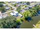 Aerial view showcasing the property's proximity to a pond with a dock and mature trees at 3585 Brooklyn Ave, Port Charlotte, FL 33952