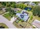 Birds eye view of home highlighting a metal roof, mature landscaping, and a tranquil pond at 3585 Brooklyn Ave, Port Charlotte, FL 33952