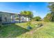 Lush backyard featuring a screened-in pool area and a mature lemon tree at 3585 Brooklyn Ave, Port Charlotte, FL 33952