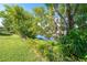 Green backyard featuring black chain link fence near trees and a canal at 3585 Brooklyn Ave, Port Charlotte, FL 33952