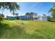 Spacious backyard featuring a well-maintained lawn, pool, utility shed, and lush greenery for outdoor enjoyment at 3585 Brooklyn Ave, Port Charlotte, FL 33952