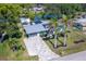 Charming, light-blue home with a modern metal roof, decorative driveway, and tropical landscaping at 3585 Brooklyn Ave, Port Charlotte, FL 33952