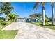 Charming one-story home with a light blue exterior, a patterned driveway and tropical landscaping at 3585 Brooklyn Ave, Port Charlotte, FL 33952