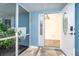 Inviting front porch with a tiled floor, screened walls and an open door, showing natural light at 3585 Brooklyn Ave, Port Charlotte, FL 33952