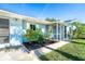 Beautiful light blue home with well-kept landscaping, stone pathway, and cozy screened front porch at 3585 Brooklyn Ave, Port Charlotte, FL 33952