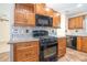 Kitchen equipped with a gas range, sleek black appliances, and wooden cabinets offering storage at 3585 Brooklyn Ave, Port Charlotte, FL 33952
