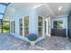 Outdoor patio with paver flooring and a vibrant plant, enclosed by a screened lanai at 3585 Brooklyn Ave, Port Charlotte, FL 33952
