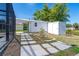 Backyard utility shed with adjacent covered parking featuring a concrete pathway at 3585 Brooklyn Ave, Port Charlotte, FL 33952