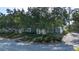 Exterior view of a two-story condo with screened balconies, lush landscaping and mature trees at 3745 Almeria Ave # 7S, Sarasota, FL 34239