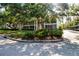 Exterior view of a two-story condo with screened balconies and mature landscaping at 3745 Almeria Ave # 7S, Sarasota, FL 34239