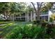 Screened balconies on a two-story condo building with lush landscaping around the green lawn at 3745 Almeria Ave # 7S, Sarasota, FL 34239