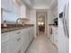 Galley kitchen with granite counters, white cabinets, and modern appliances, offering a functional cooking space at 3745 Almeria Ave # 7S, Sarasota, FL 34239