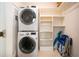 Efficient laundry room with stacked washer and dryer, plus built-in shelving for organization at 3745 Almeria Ave # 7S, Sarasota, FL 34239