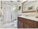 Bathroom with glass enclosed shower, vanity with dark wood cabinets, and a decorative mirror at 3820 Ironwood Ln # 104-I, Bradenton, FL 34209