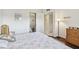 Comfortable bedroom with a view into another room; features a dresser and a lamp at 3820 Ironwood Ln # 104-I, Bradenton, FL 34209