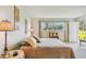 Bright bedroom featuring a large window with exterior view and side door access at 3820 Ironwood Ln # 104-I, Bradenton, FL 34209