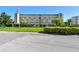Well-maintained condo building exterior with covered parking, manicured landscaping, and American flag at 3820 Ironwood Ln # 104-I, Bradenton, FL 34209