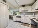 Traditional kitchen with white cabinets, tile floors, and modern appliances offers a cozy and functional design at 3820 Ironwood Ln # 104-I, Bradenton, FL 34209