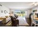 Spacious living room featuring dark hardwood floors, plush seating, and sliding glass doors to the outdoors at 3820 Ironwood Ln # 104-I, Bradenton, FL 34209