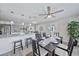Open-concept dining area with a table setting, ceiling fan, and bright views to the kitchen and living area at 400 E Baffin Dr, Venice, FL 34293