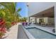 Backyard haven with lush tropical landscaping, cozy seating, and a tranquil water feature enhancing outdoor relaxation at 401 39Th St, Holmes Beach, FL 34217