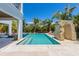 Serene backyard featuring a sparkling pool, lounge area, and lush tropical plants, perfect for relaxation and outdoor enjoyment at 401 39Th St, Holmes Beach, FL 34217