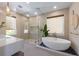 Bright bathroom with a modern soaking tub, glass shower, double sink, and pebble accents at 401 39Th St, Holmes Beach, FL 34217